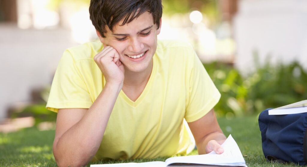 Teen outside working on summer homework assignment