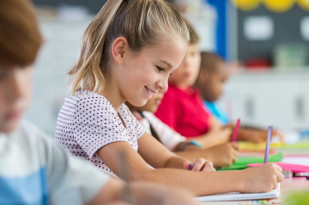 Female student writing in a classroom.